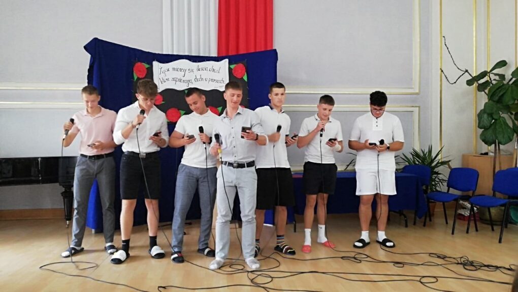 Zdjęcie siedmiu uczniów śpiewających przez mikrofon. 