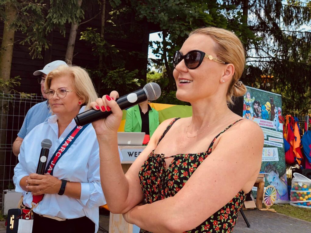 Zdjęcie kobiety przemawiającej przez mikrofon.
