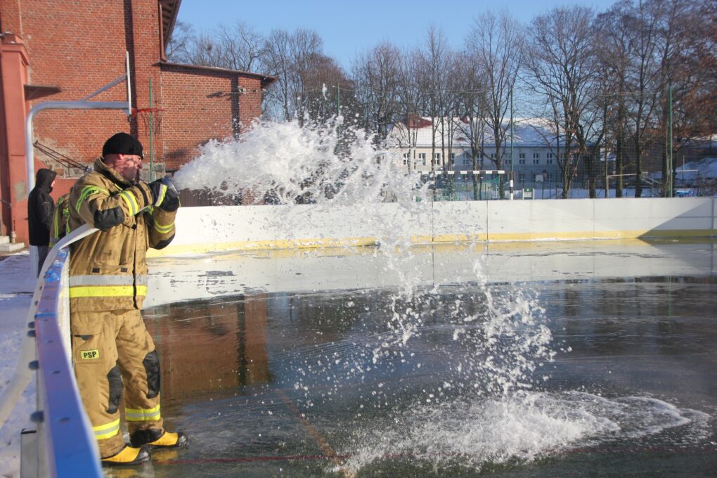Przedstawia strażaka uzupełniającego wodę 